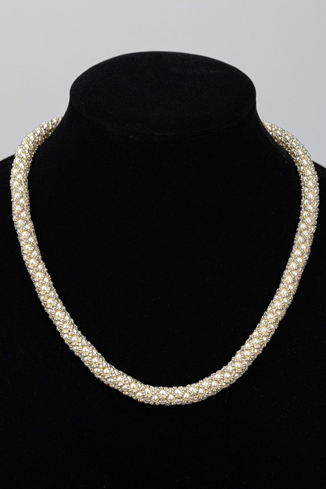 A necklace is shown on the neck of a woman.