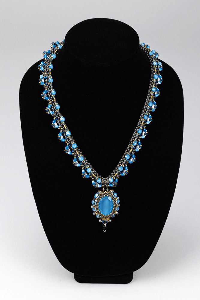 A necklace with blue beads and a pendant.