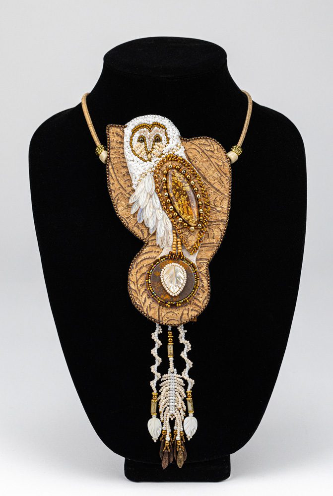 A necklace with an owl on it's side.