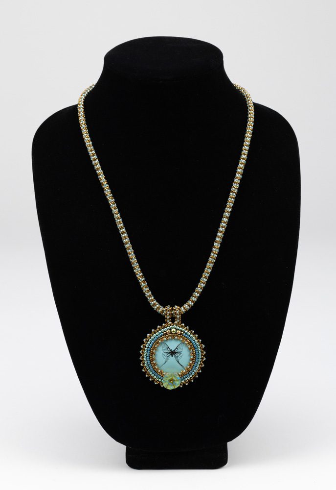 A necklace with a blue and green pendant on it.