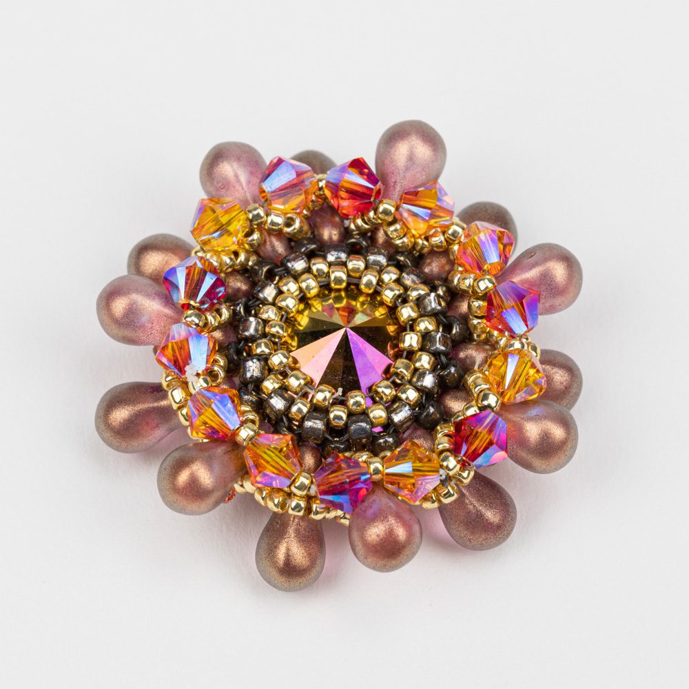 A close up of a brooch with beads