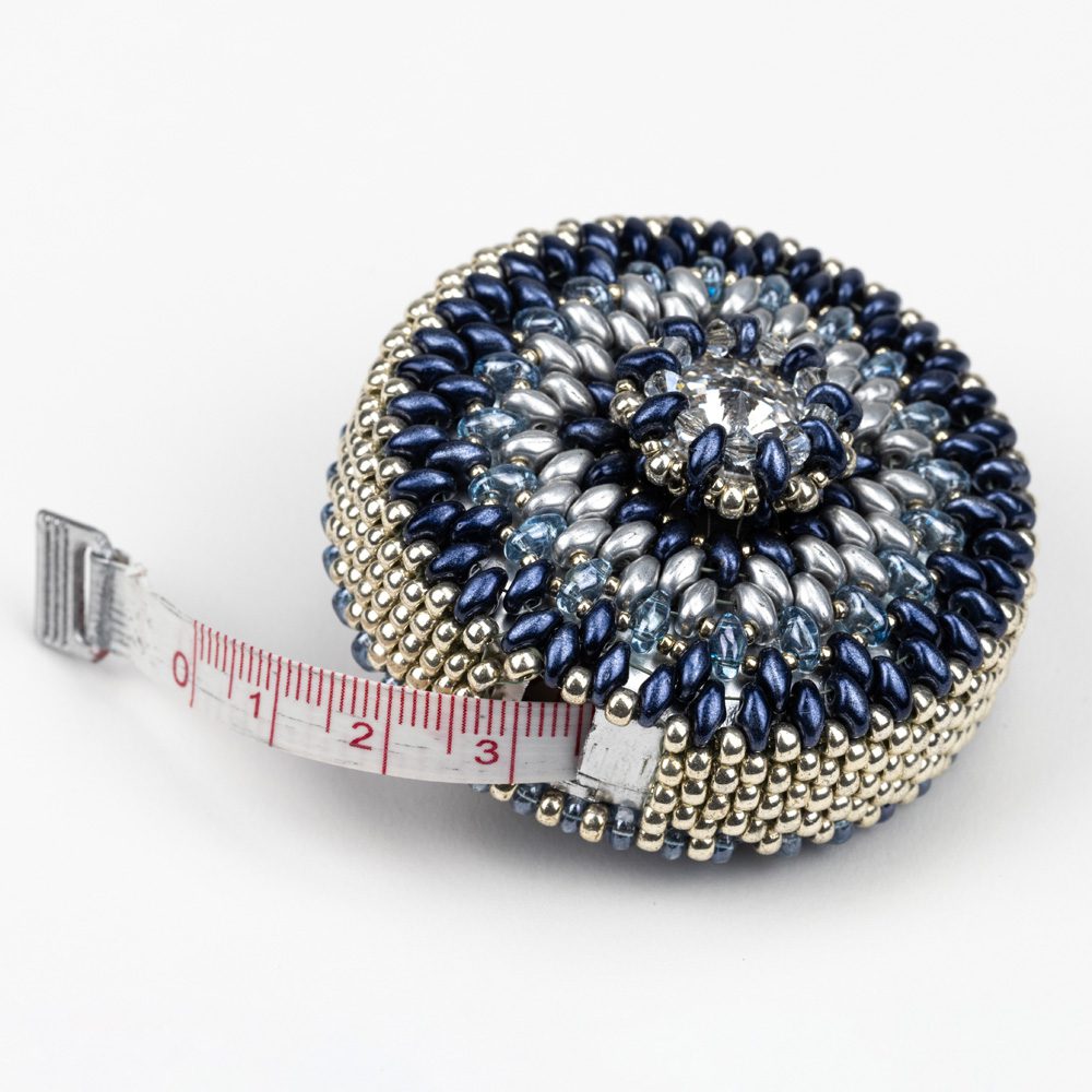 A tape measure with blue and silver beads on it.