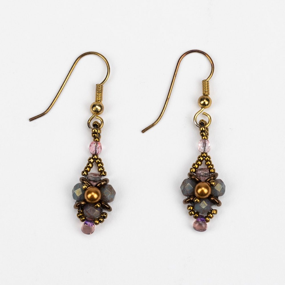 A pair of earrings with gold and purple beads.