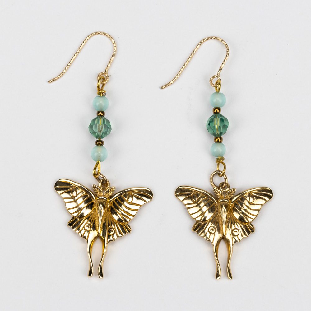 A pair of gold earrings with an elephant and butterfly.