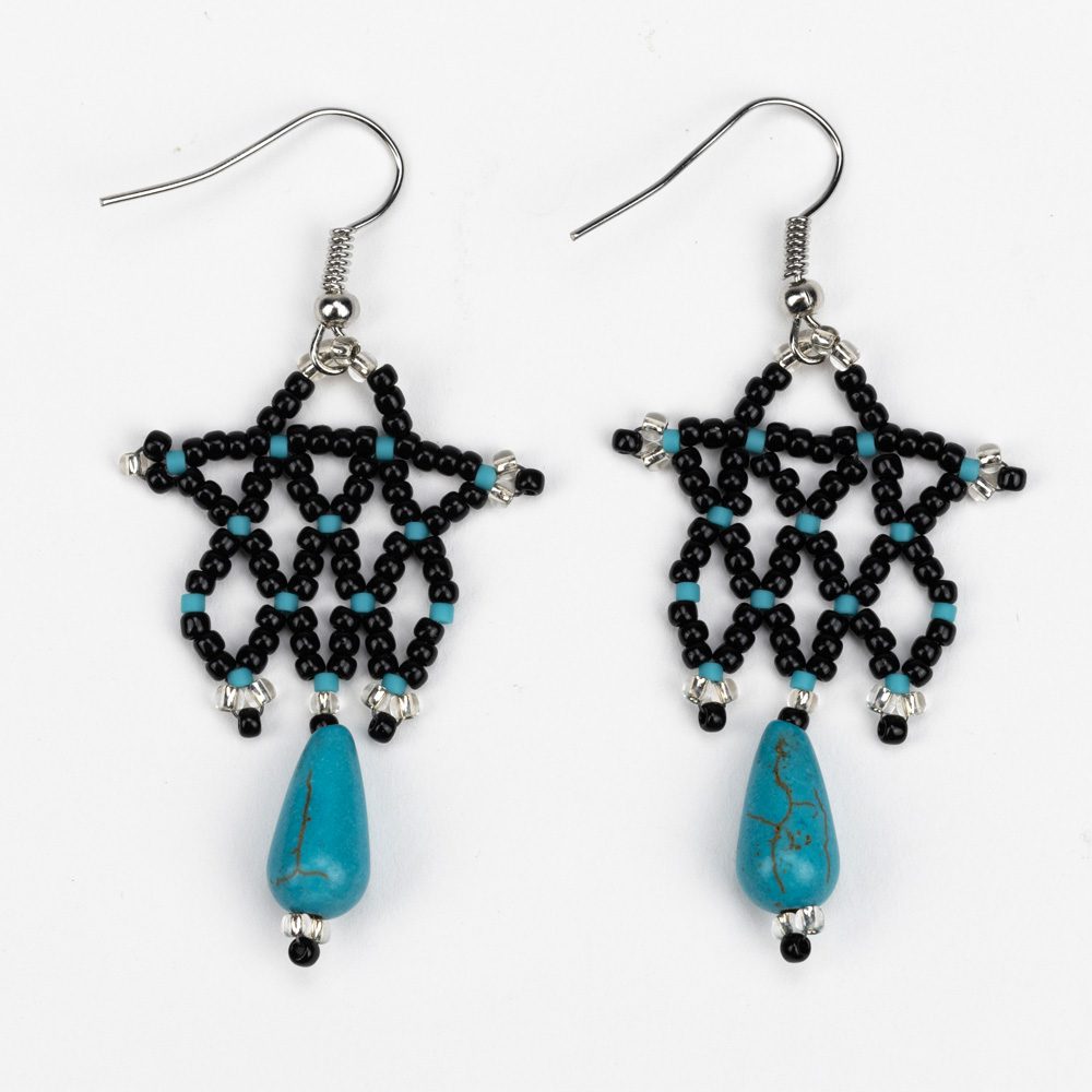 A pair of earrings with beads and turquoise.