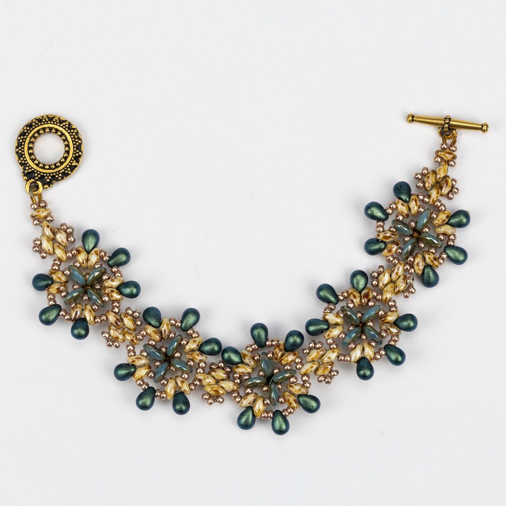 A gold bracelet with green beads and a toggle clasp.