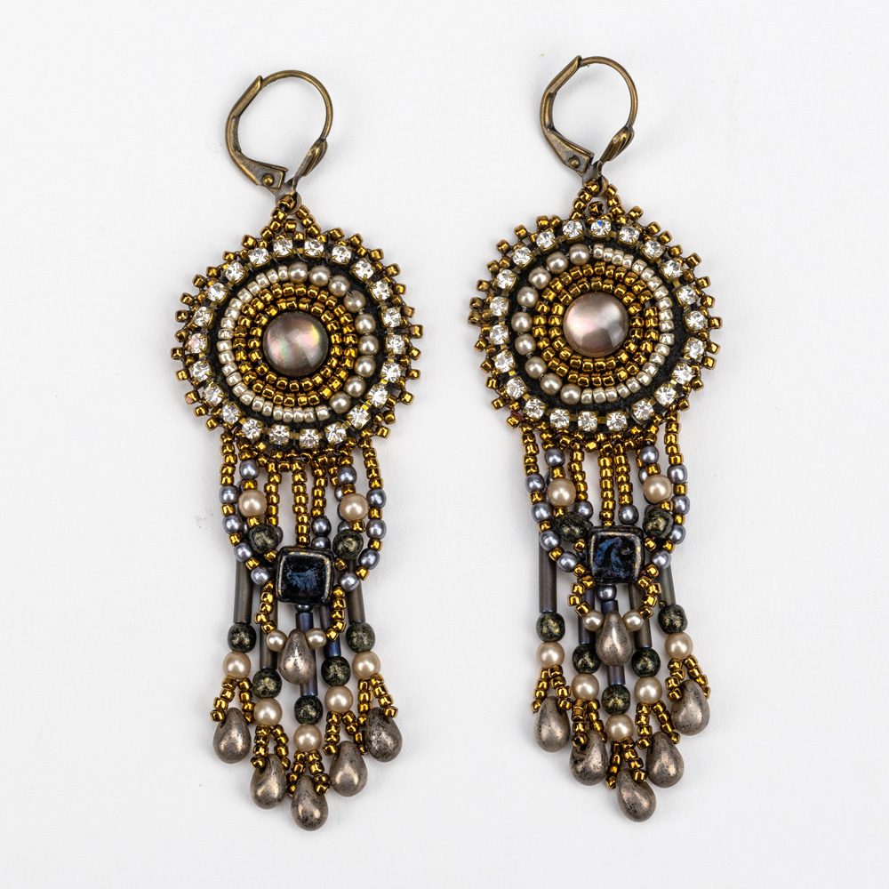 A pair of earrings with chains and beads hanging from them.