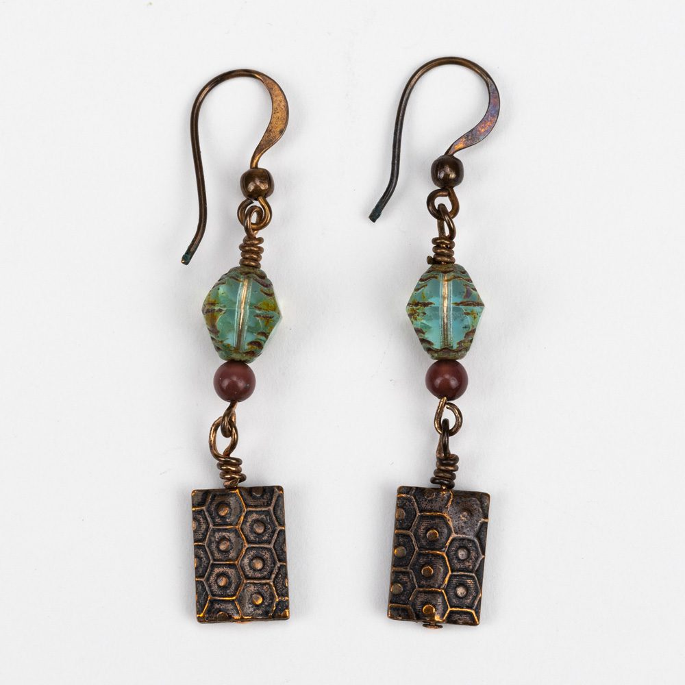 A pair of earrings with a square shaped bead and a small bead.