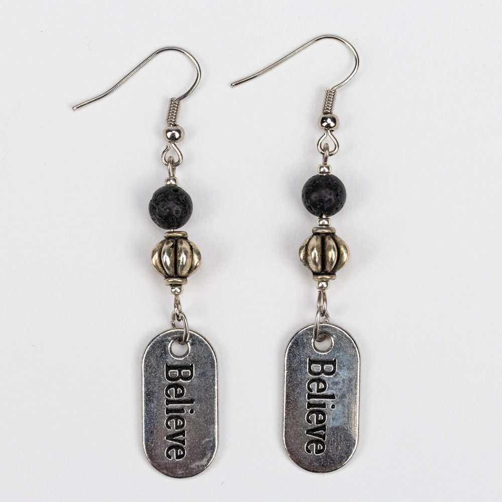 A pair of earrings with the word " believe " on them.