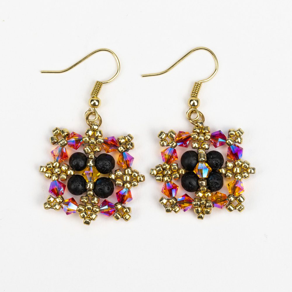 A pair of earrings with gold and black beads.